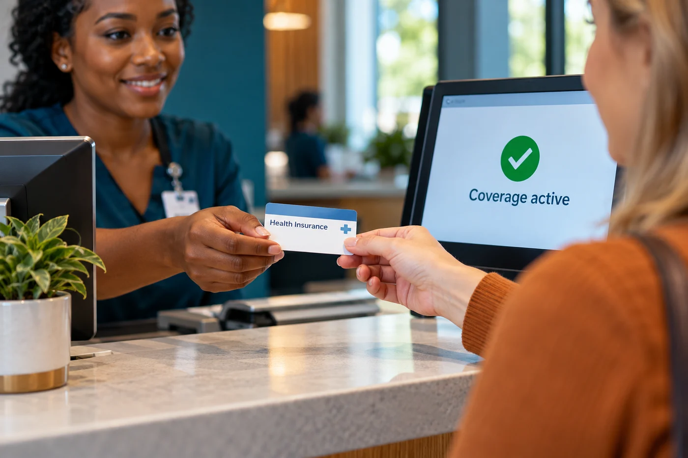 Receptionist checking a health insurance card against an active coverage screen